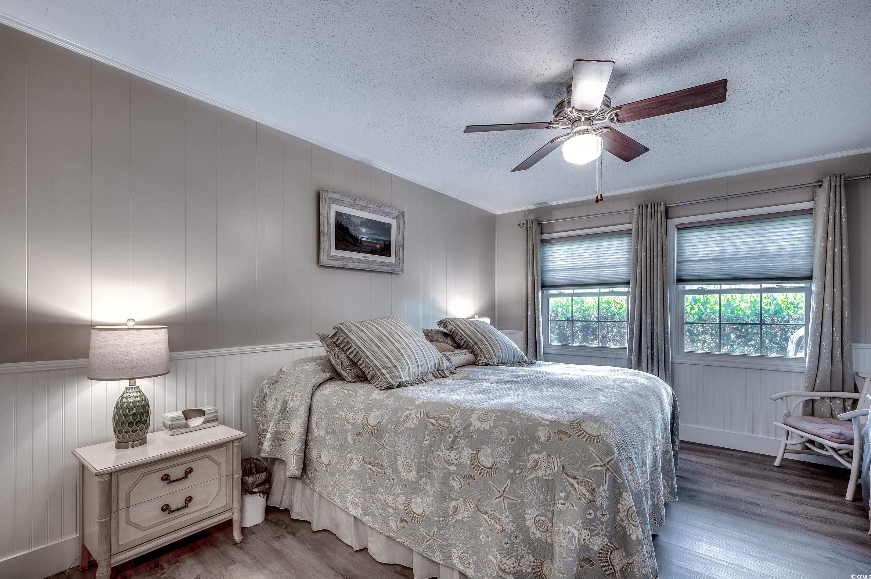 416 North Ocean Boulevard, Unit B7 Surfside Beach, SC 29575 - Photo 18 of 30 Bedroom with wood finished floors, a textured ceiling, a ceiling fan, and ornamental molding