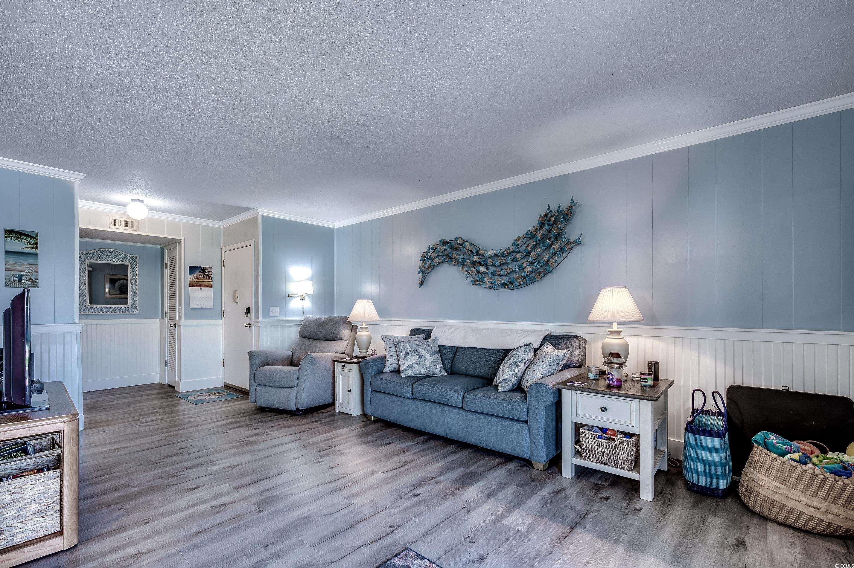 416 North Ocean Boulevard, Unit B7 Surfside Beach, SC 29575 - Photo 6 of 30 Living room with wood finished floors, a textured ceiling, crown molding, and wainscoting