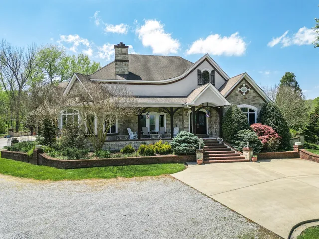 an aerial view of residential house with outdoor space and trees all around