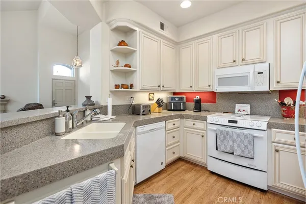 a kitchen with cabinets appliances a sink and a counter top space