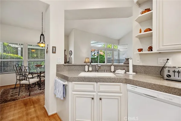 a kitchen with granite countertop a sink a stove and cabinets