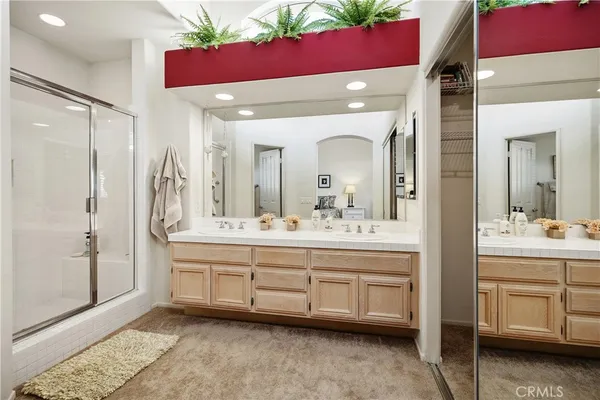 a bathroom with a double vanity sink mirror and shower
