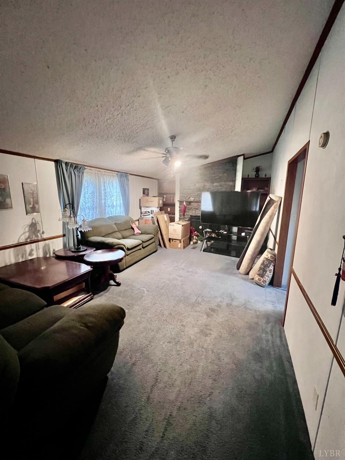 5507 Wards Road Evington, VA 24550 - Photo 13 of 15 a living room with furniture a window and a flat screen tv