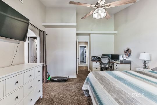 1220 Jennifer Court Ridgecrest, CA 93555 - Photo 23 of 34 a bedroom with a bed and a chandelier