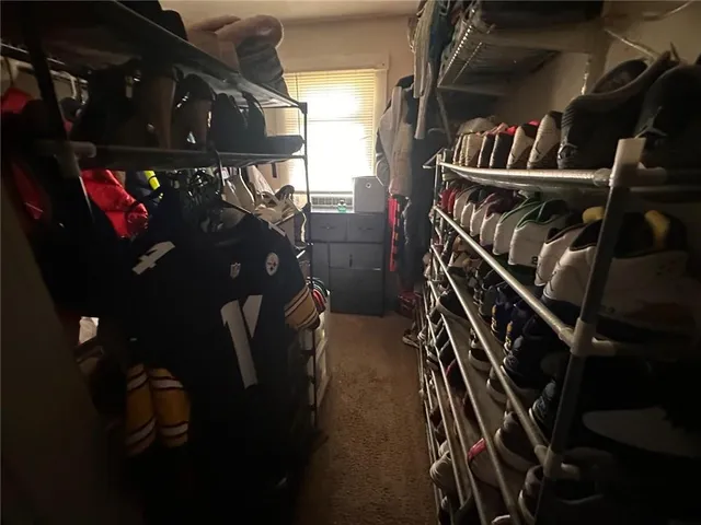 a view of walk in closet with clothes and shoes