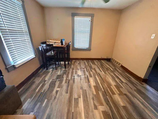 a view of a room with wooden floor and furniture