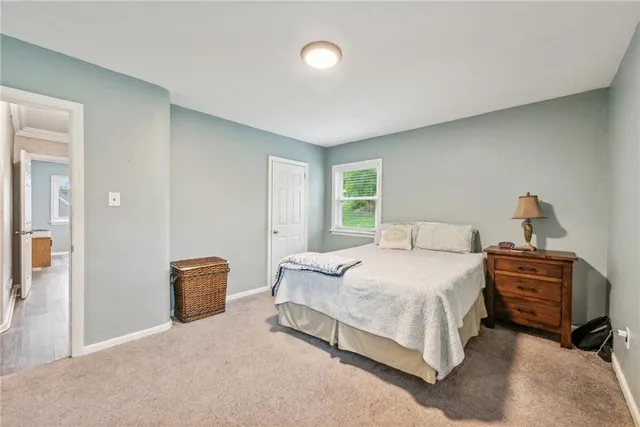 a bedroom with a bed lamp and a dresser