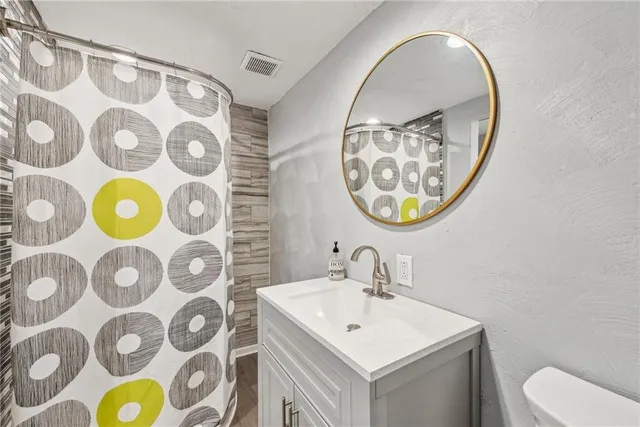 a bathroom with a sink mirror vanity and toilet