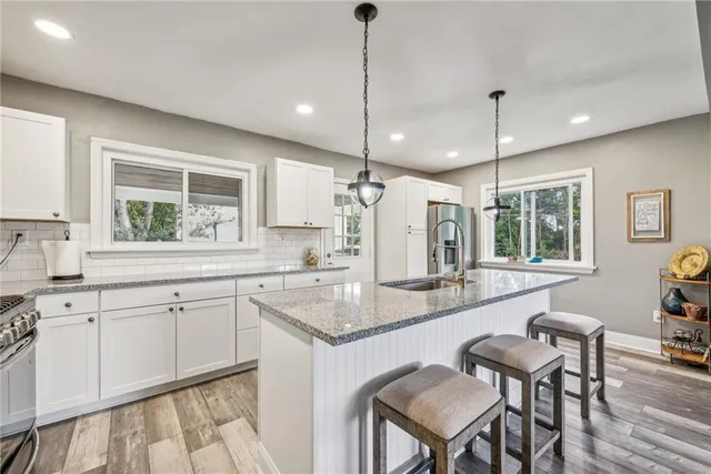 a kitchen with a dining table chairs sink and cabinets