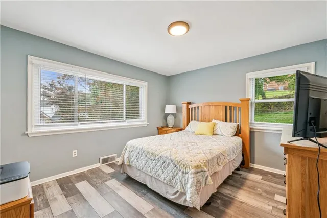 a bedroom with a bed and a flat tv screen on the dresser