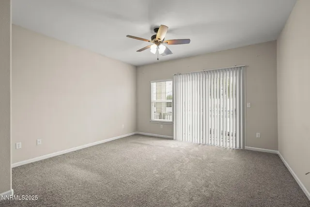 a view of a livingroom with a ceiling fan and window
