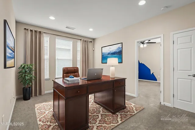 a view of a workspace with furniture and a window