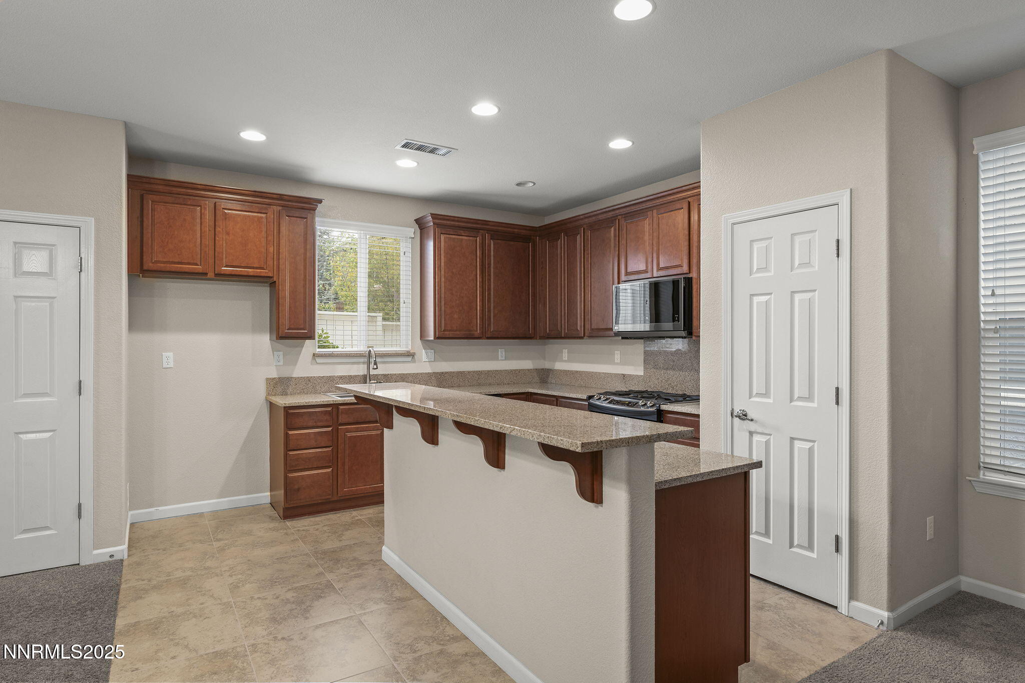 2040 Alamo Square Way Reno, NV 89509 - Photo 9 of 39 a kitchen with stainless steel appliances granite countertop a stove a refrigerator a sink dishwasher and a refrigerator with wooden cabinets