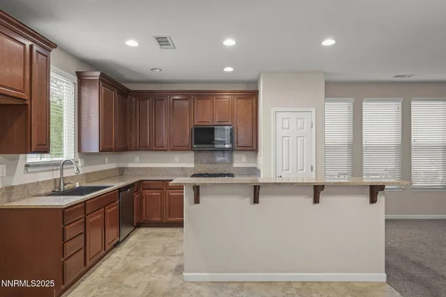 a kitchen with a sink window and cabinets