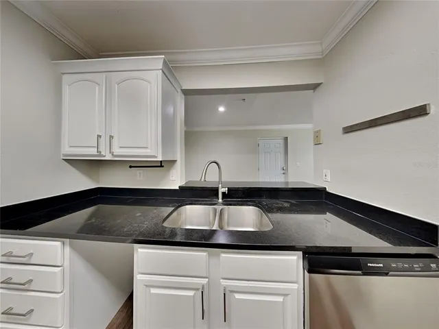 a kitchen with white cabinets and a sink