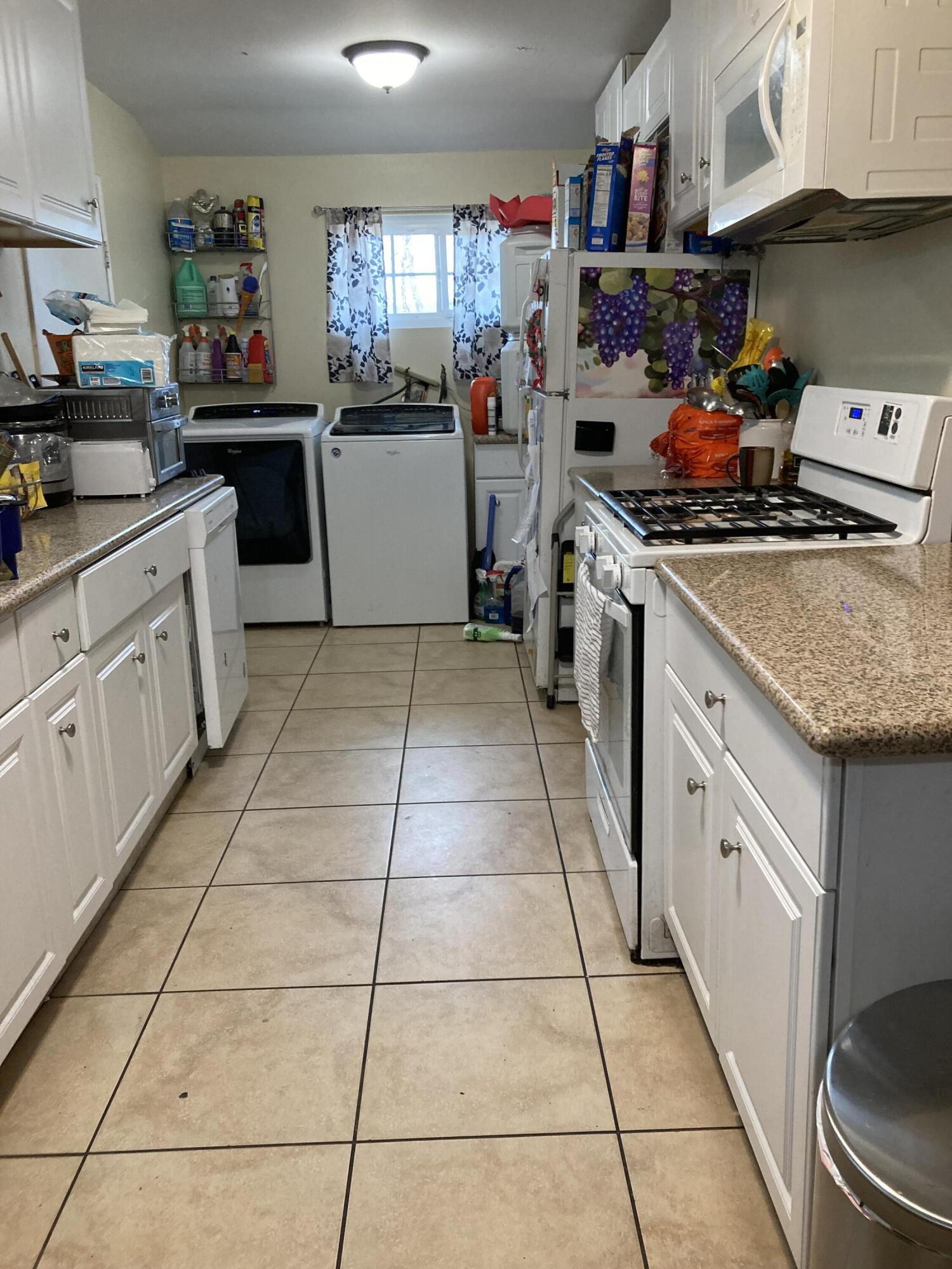 45360 Raysack Avenue Lancaster, CA 93535 - Photo 5 of 25 a kitchen with stainless steel appliances granite countertop a stove a sink and a refrigerator