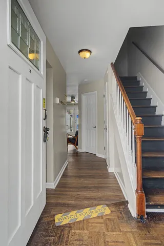 a view of a hallway with wooden floor and staircase