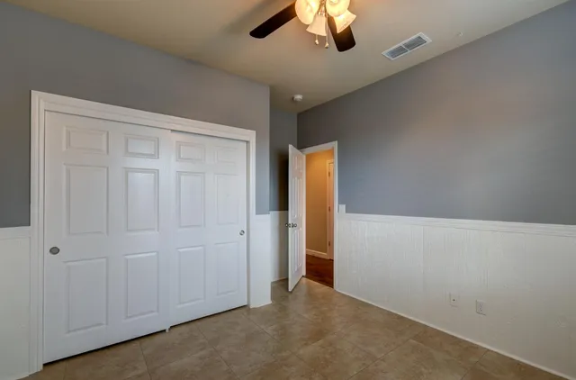 an empty room with a chandelier fan
