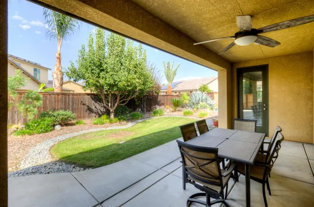 a view of a patio with table and chairs potted plants with wooden floor and fence
