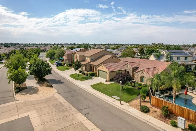 an aerial view of residential houses with outdoor space and lakeside
