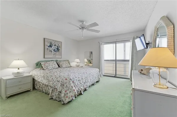 a bedroom with a bed painting on wall and windows