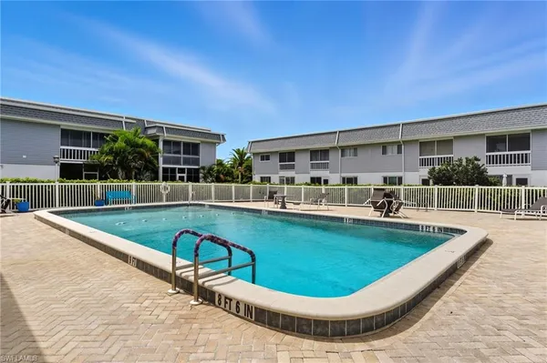 a view of a house with swimming pool and sitting area