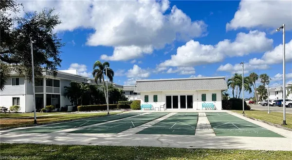 a view of a white house in front of a big yard
