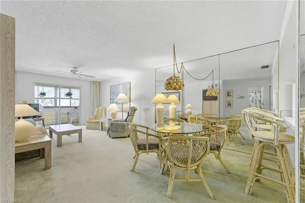 a dining room with furniture a chandelier and wooden floor