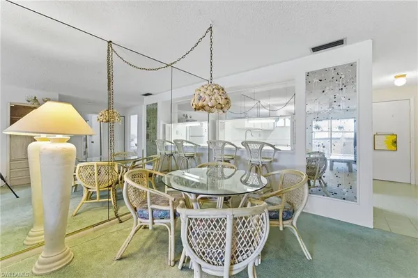 a dining room with furniture a chandelier and wooden floor