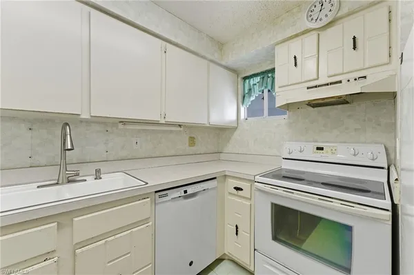 a kitchen with white cabinets and white appliances