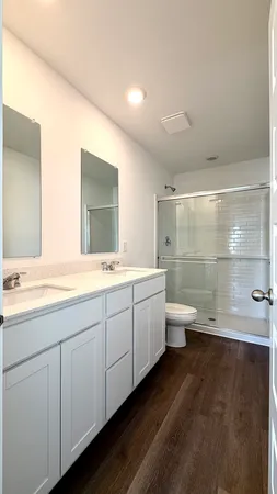 a bathroom with a double vanity sink toilet and a tub