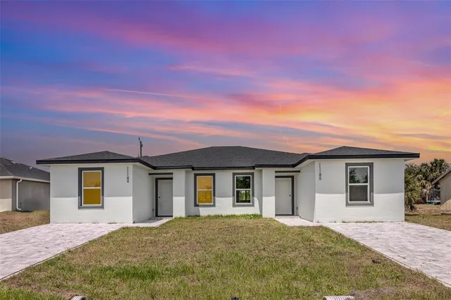 a front view of a house with a garden