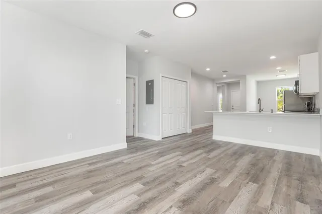 a view of an empty room with wooden floor