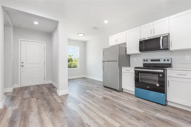 a view of kitchen with microwave and cabinets