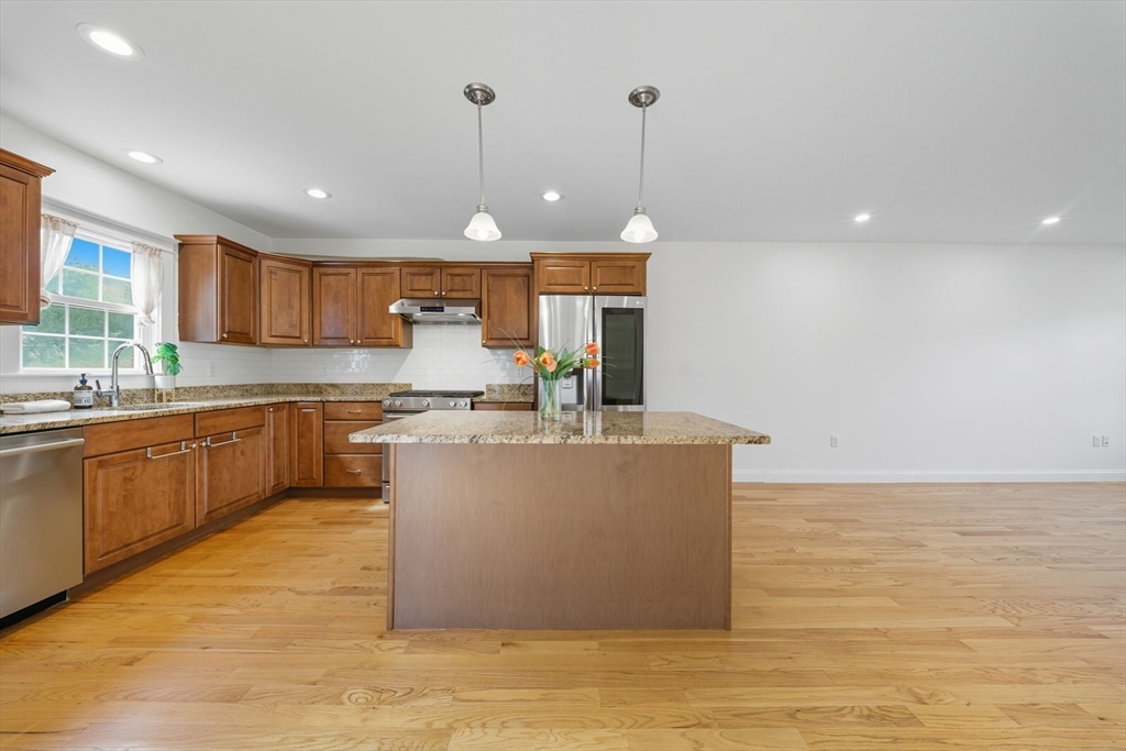 3 Spotted Turtle Path, Unit 242 Canton, MA 02021 - Photo 8 of 36 a view of a kitchen with kitchen island a stove a sink a refrigerator and a counter top space