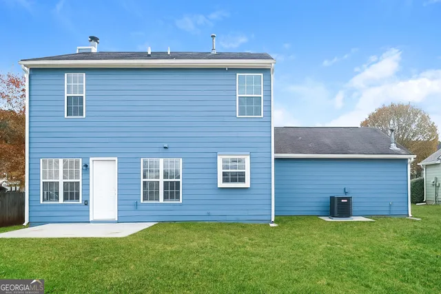 a brick house that has a small yard and a large window