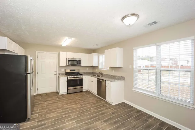 a kitchen with stainless steel appliances granite countertop a stove and a refrigerator