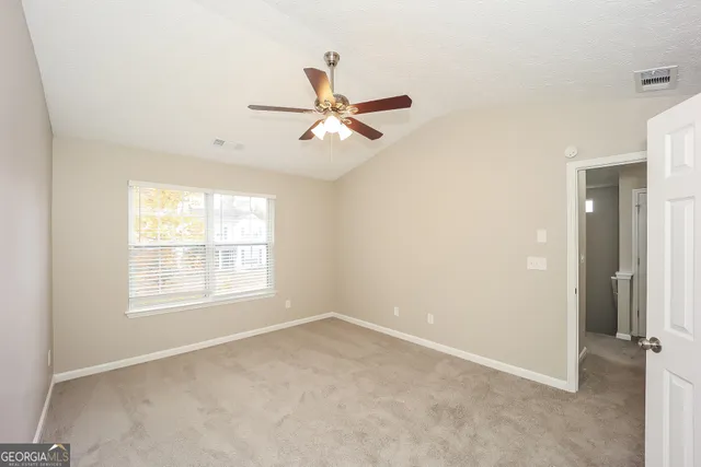 an empty room with fan and windows
