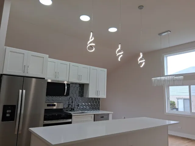 a kitchen with stainless steel appliances a stove refrigerator sink and microwave