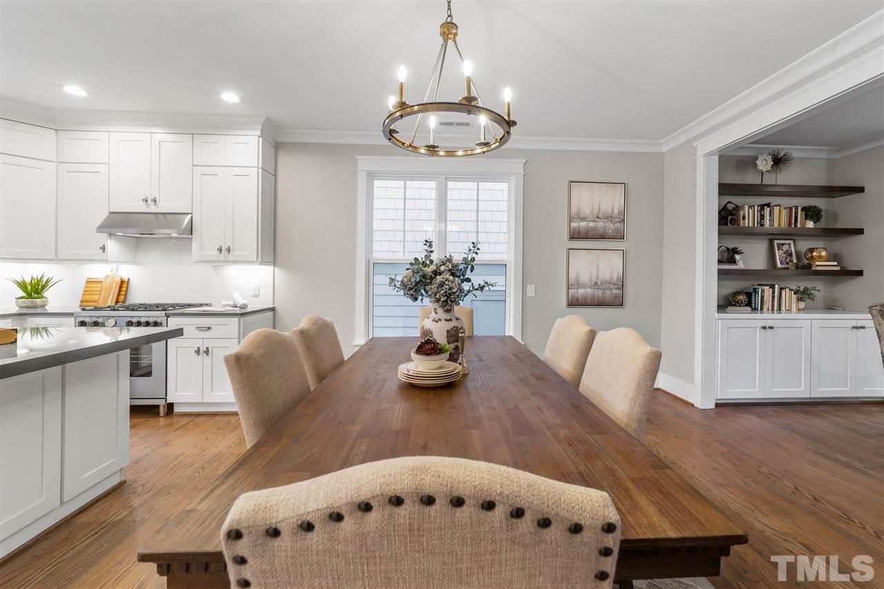 507 Hamilton Cottage Way Raleigh, NC 27605 - Photo 8 of 30 a kitchen with stainless steel appliances granite countertop a dining table chairs and a dining table with wooden floor