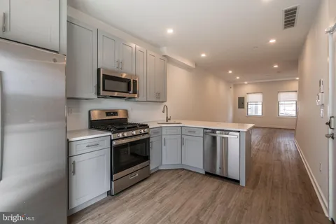 a kitchen with stainless steel appliances granite countertop a stove a sink and a microwave