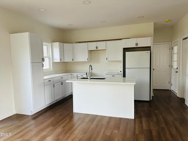a kitchen with a refrigerator sink and cabinets