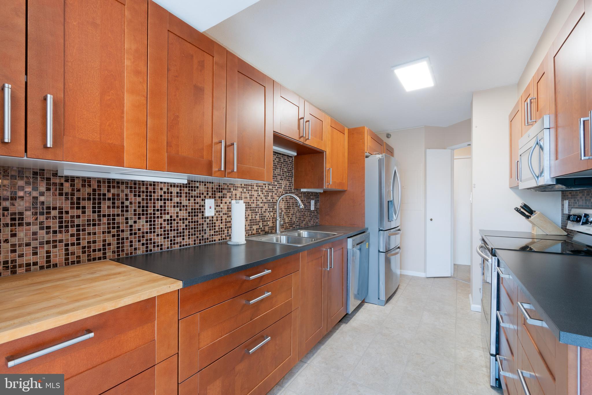 15115 Interlachen Drive, Unit 3607 Silver Spring, MD 20906 - Photo 11 of 37 a kitchen with granite countertop a sink stove and refrigerator