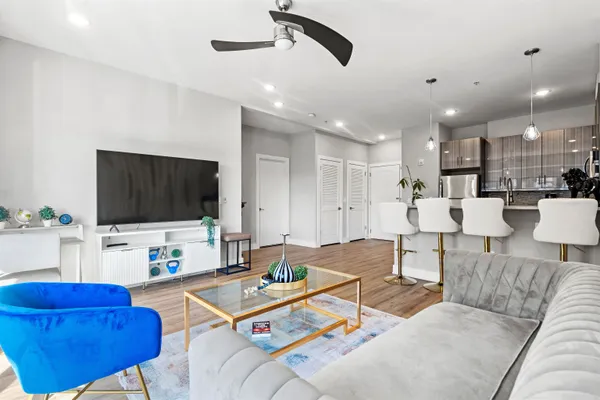 a living room with furniture kitchen view and a flat screen tv