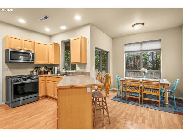 a kitchen with stainless steel appliances kitchen island granite countertop a stove and a view of living room