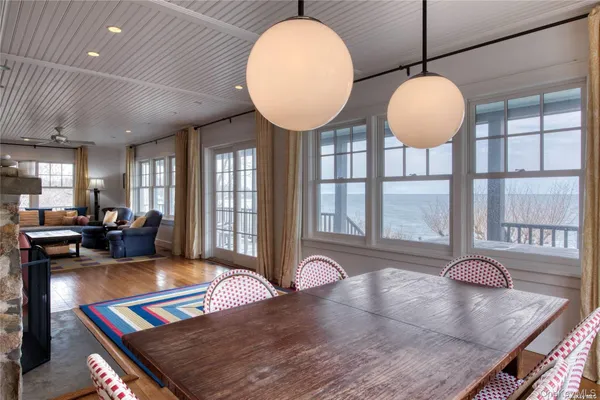 a kitchen with stainless steel appliances granite countertop a stove a sink a dining table and chairs with wooden floor