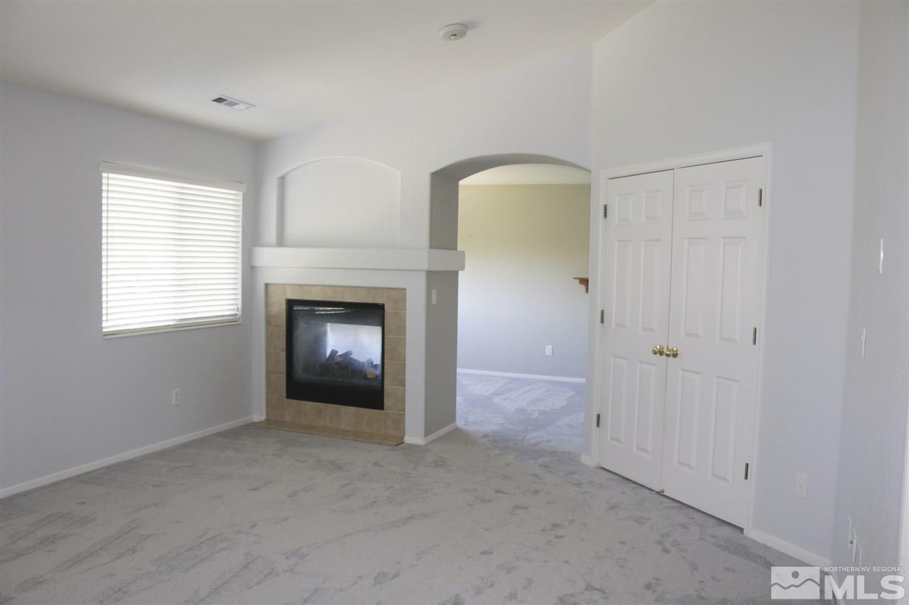 402 Solitude Court Reno, NV 89511 - Photo 10 of 17 a view of an empty room with a window and fireplace