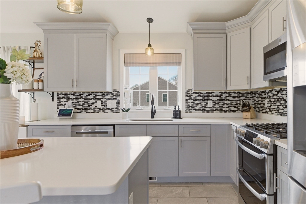 341 Courtney Street Fall River, MA 02720 - Photo 12 of 39 a kitchen with stainless steel appliances a sink stove and microwave