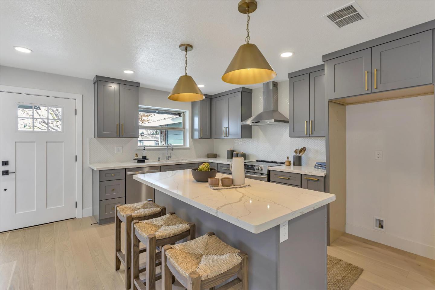 2860 Encinitas Court San Jose, CA 95132 - Photo 17 of 45 a kitchen with stainless steel appliances a sink a stove a refrigerator and white cabinets with wooden floor