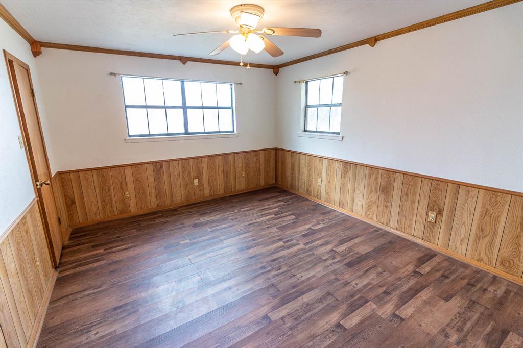 801 South Sutton Street Mabank, TX 75147 - Photo 12 of 26 a view of an empty room with wooden floor and a window